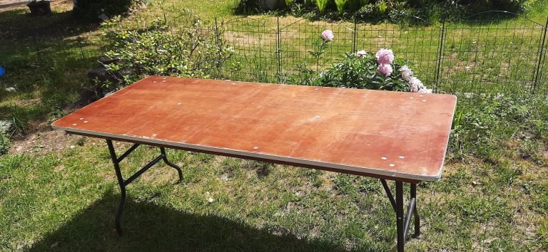 Bänke mit orangefarbenen Tischplatten auf grünem Rasen angeordnet.