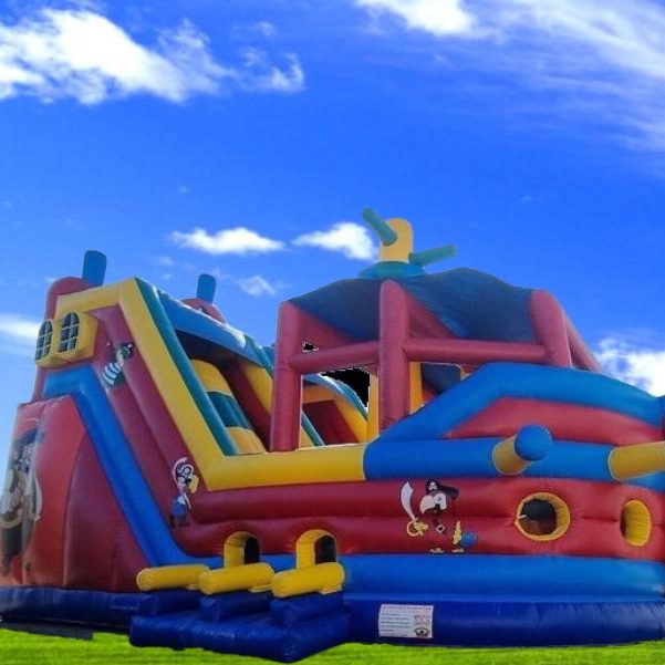 Bunte Hüpfburg in Form eines Schiffs mit Rutschen und Spielbereichen.